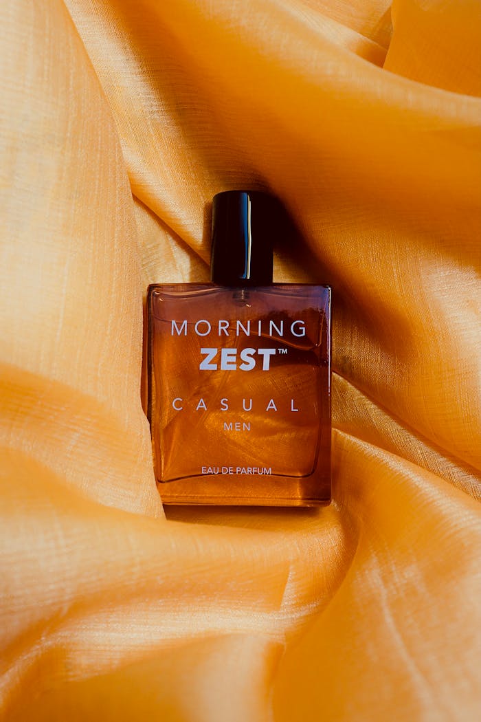 Elegant bottle of Morning Zest Men's Cologne on orange satin fabric. Perfect for lifestyle imagery.